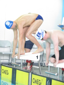 Two swimmers preparing to dive at the championships